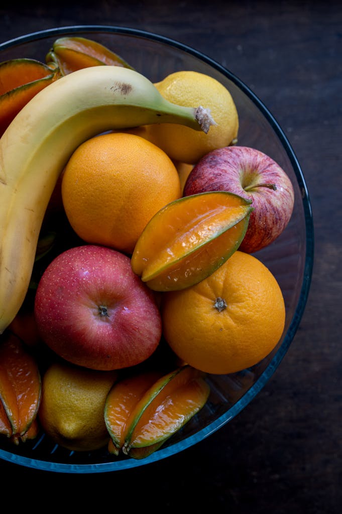 Vibrant display of assorted tropical fruits in a glass bowl, perfect for a healthy snack.